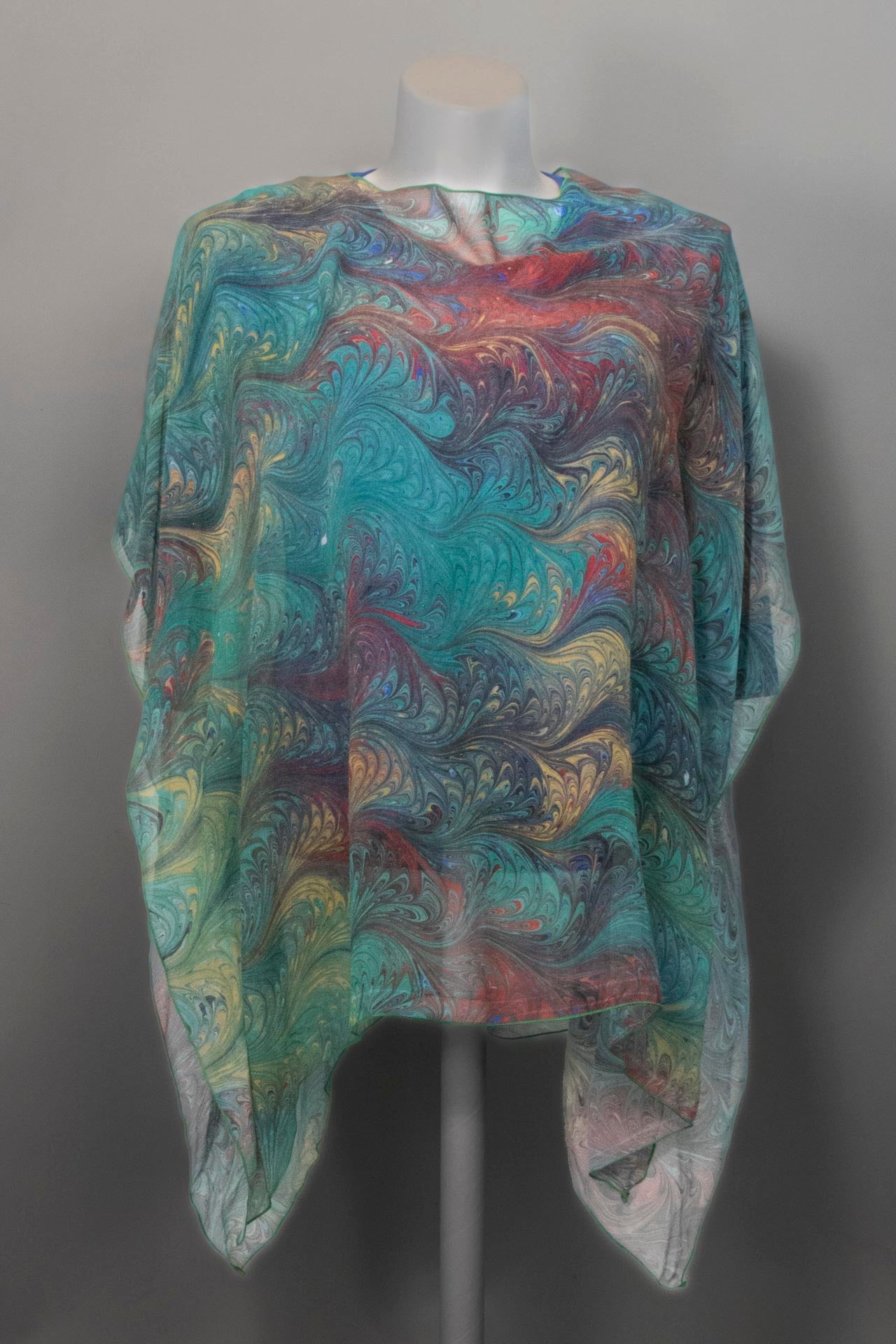 sheer poncho marbled in green with red, gold and charcoal accents