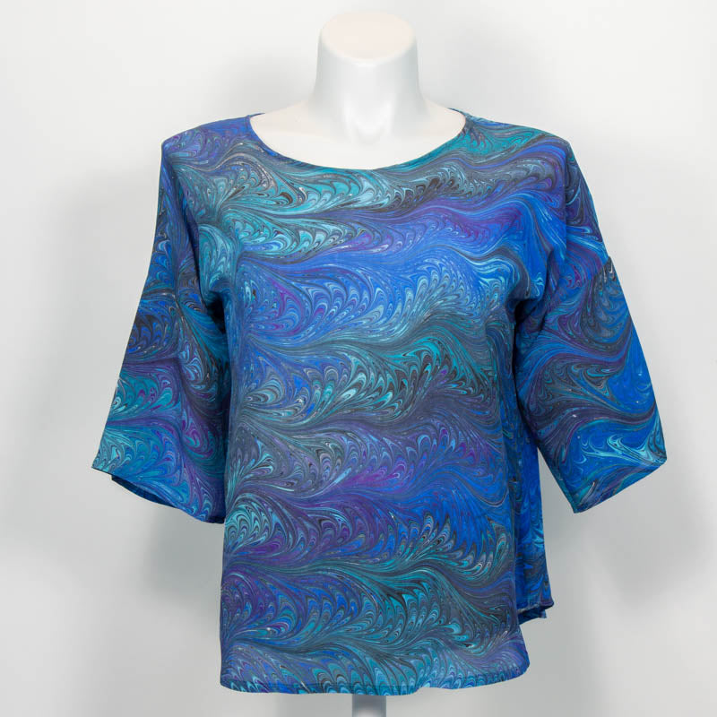 Marbled silk blouse in blue aqua teal on mannequin against white background