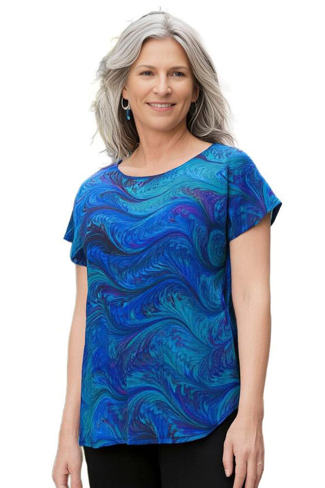 Woman wearing a blue hand marbled top on a white background