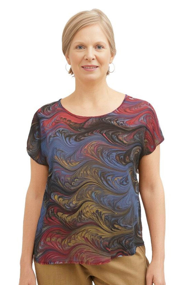 Woman wearing a hand marbled silk shirt in earth tones on a white background