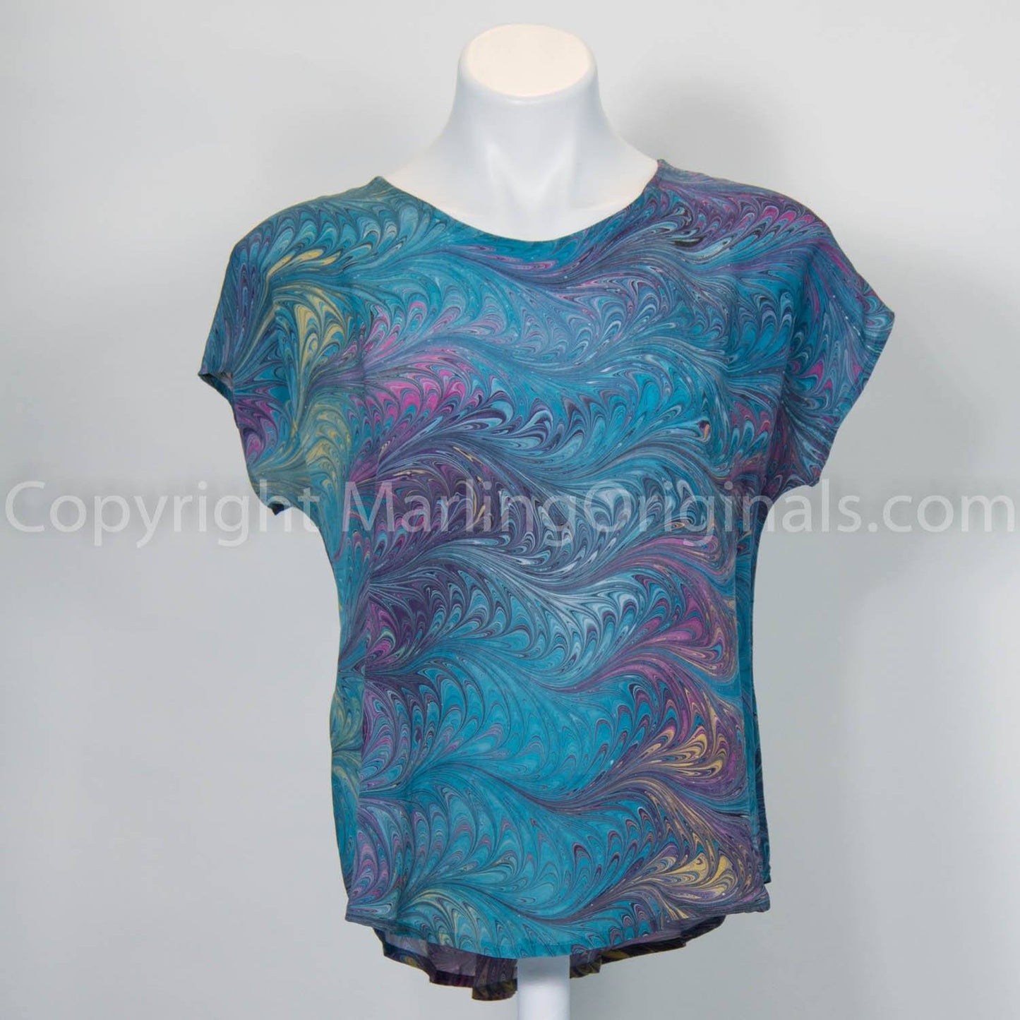 Hand marbled silk top in teal,pink, gold tones.  Short sleeve top with round neck and curved hem.