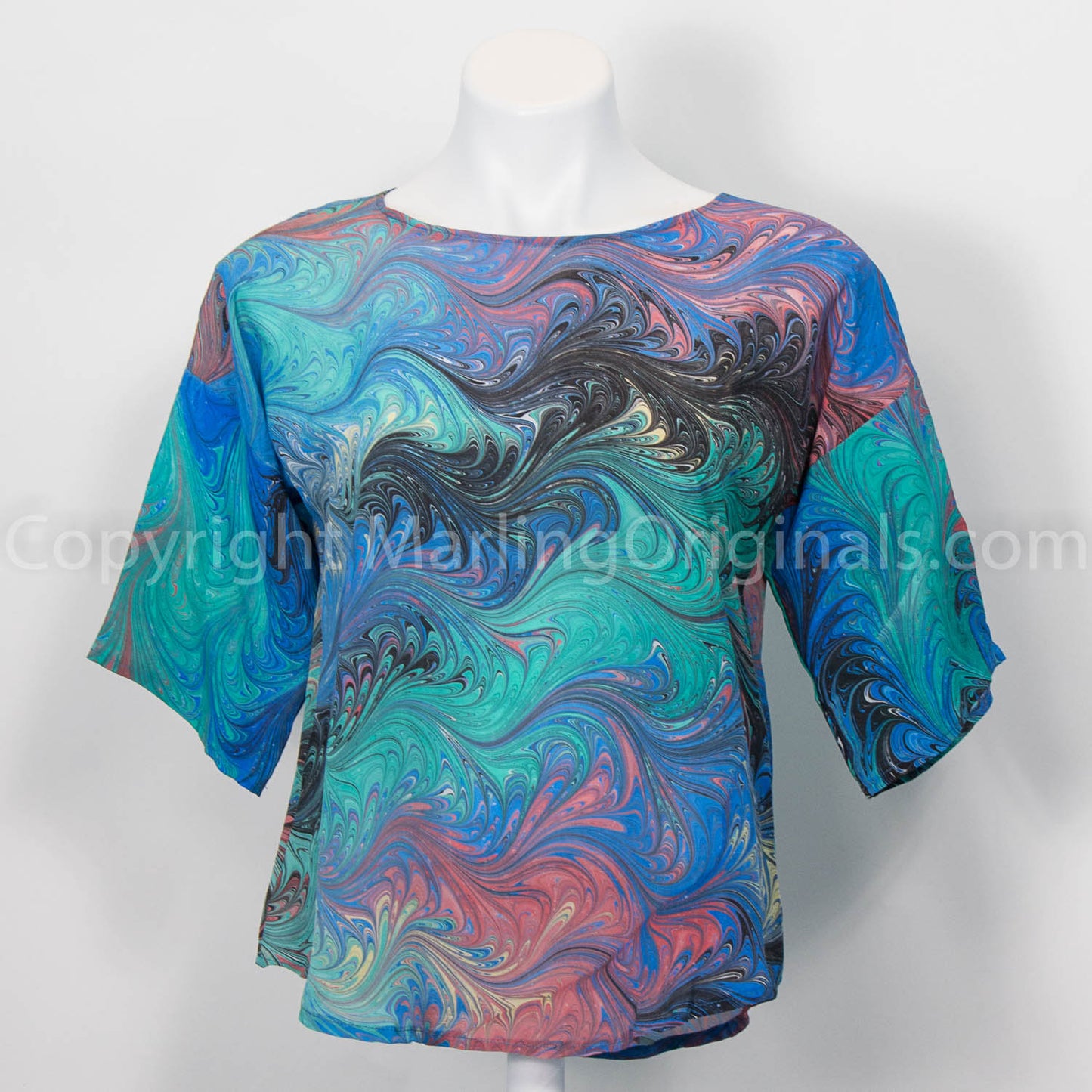 Silk top in green, blue, red and black marbled tones.  Round neck with half sleeve and curved hem.